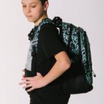 Školní batoh Baagl Core Graffito správně nasazený na obou ramenu.